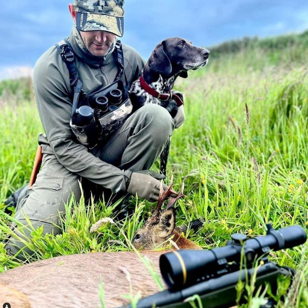 man holding dog and seeing sniper